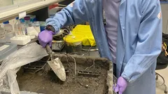 Vědec v laboratoři zapichuje sondu do hlíny s dráty