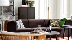 Obývací pokoj s rohovou sedačkou, konferenčním stolkem a světlým průchodem